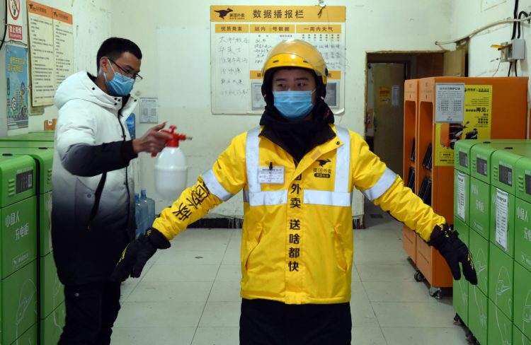 A Meituan courier being disinfected. Meituan